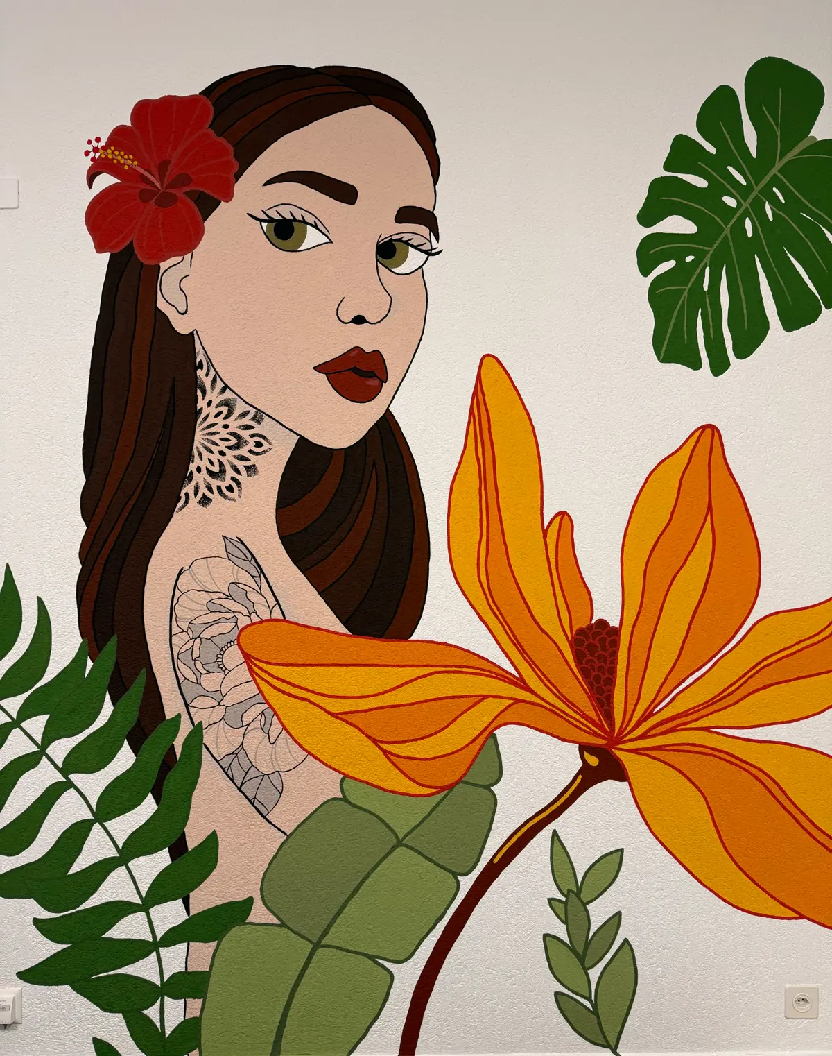Murale di una ragazza con tatuaggi, fiore rosso tra i capelli e foglie tropicali