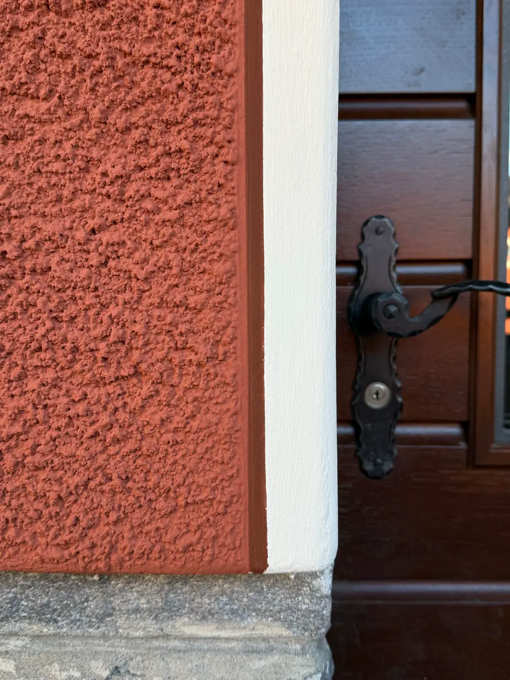 Filetto bianco attorno a una porta su facciata gialla