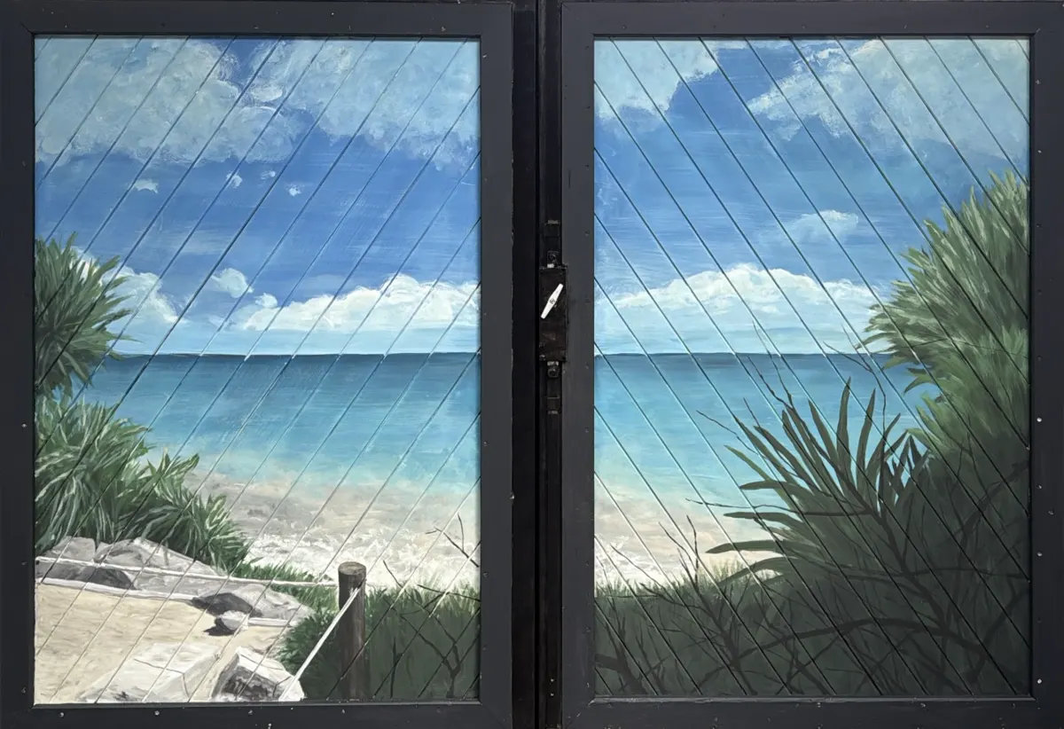 Spiaggia di Tulum dipinta sui vetri di un portone in legno